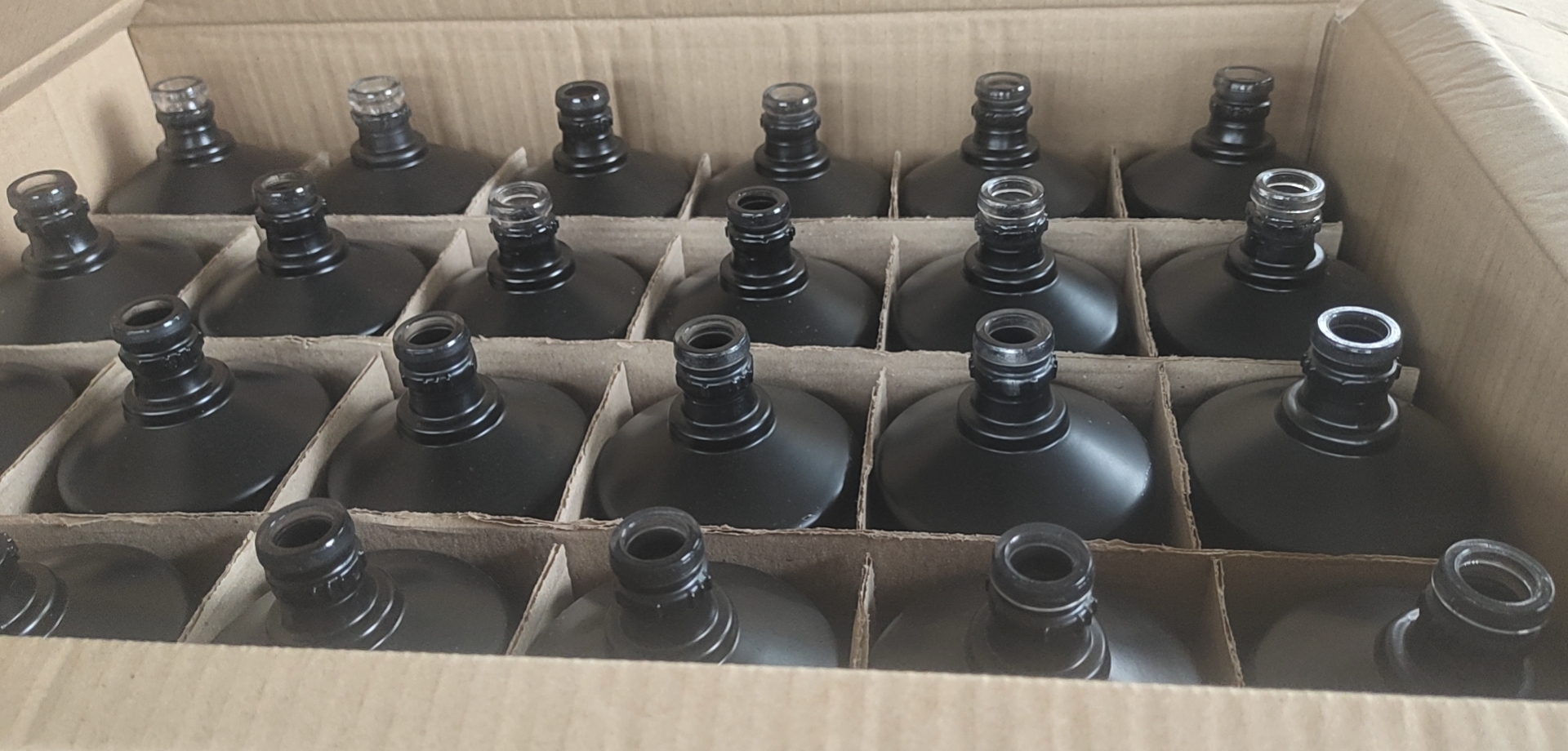 Black coated glass bottles in divider carton