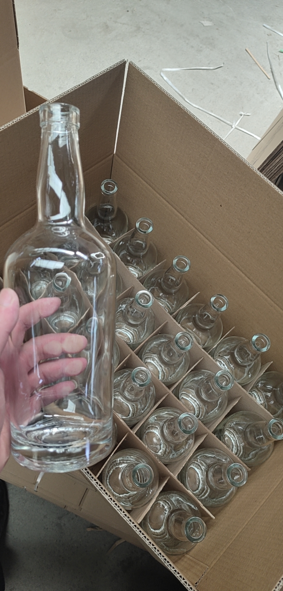 Hand placing a 750ml whisky bottle into its divider cell