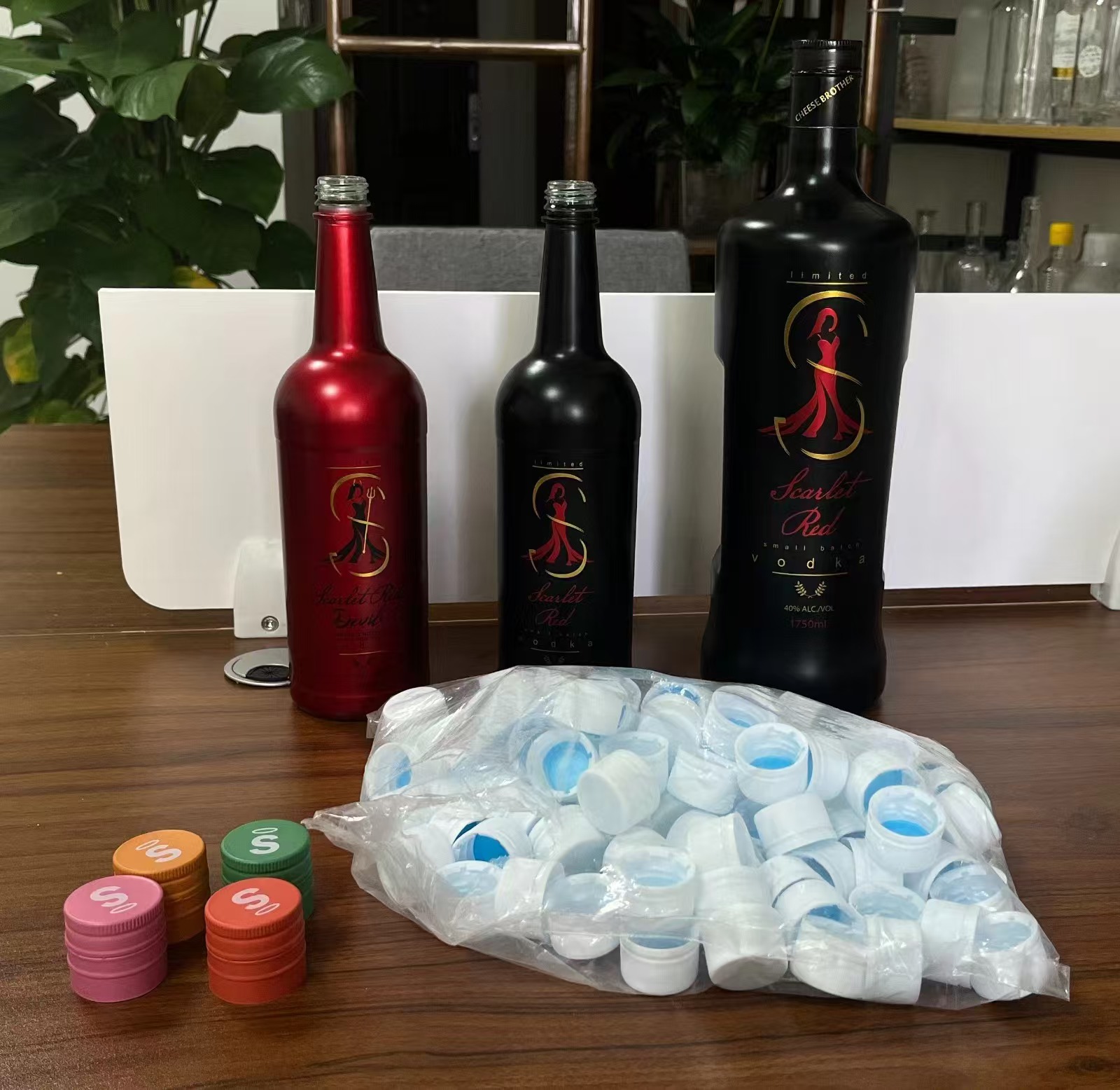 Spray painted bottles: metallic red and matte black with gold decal branding
