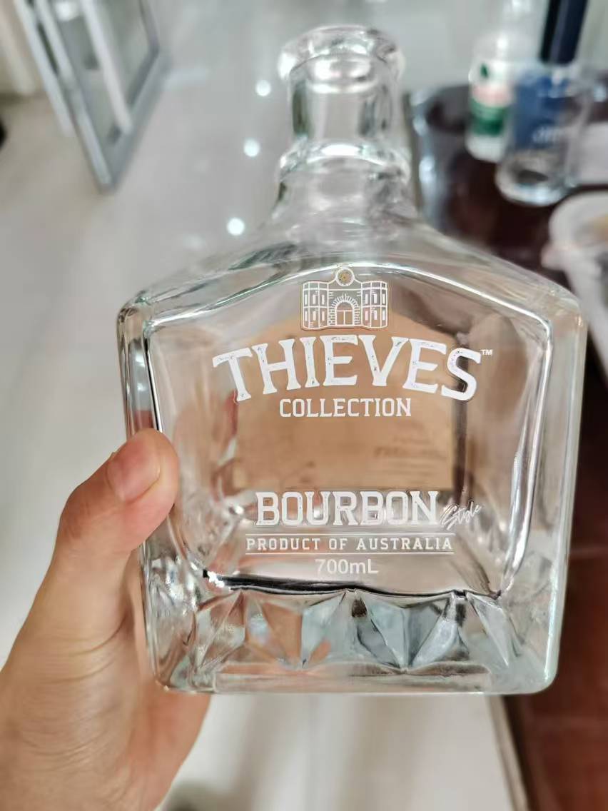 White water transfer decal with fine typography on a bourbon bottle